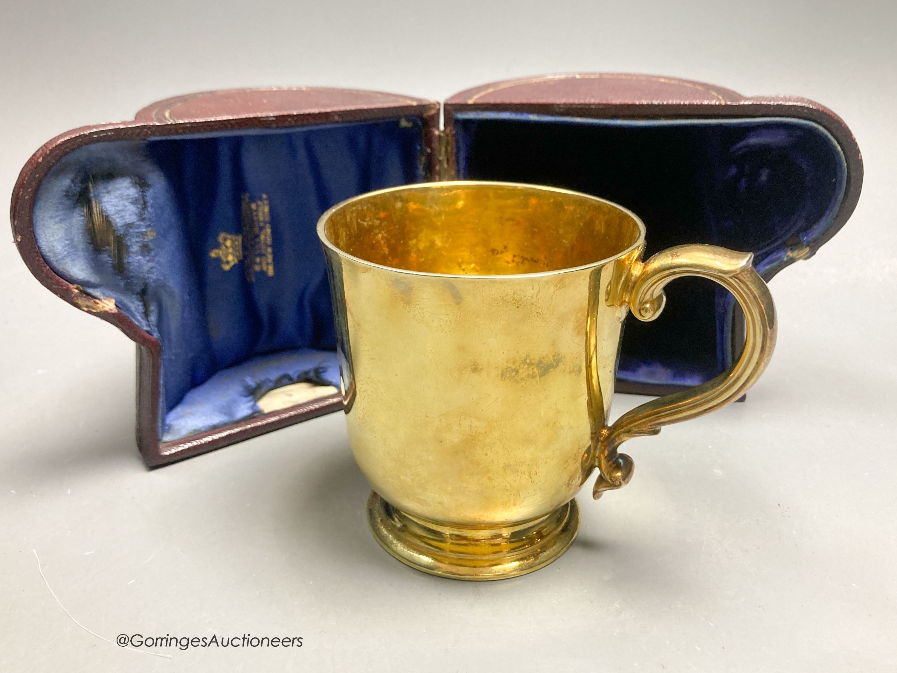 A Victorian silver gilt christening mug, by R & S. Garrard & Co, London, 1873, height 82mm, 7oz, in associated leather carrying case.